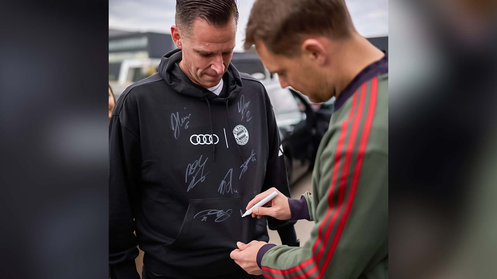 Manuel Neuer gibt ein Autogramm an einen Audi Mitarbeitenden